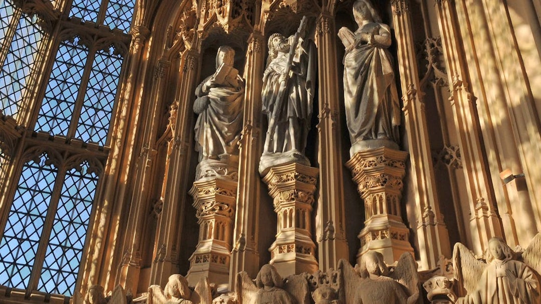 Statues inside Westminster Abbey, London, highlighting intricate Gothic architecture.