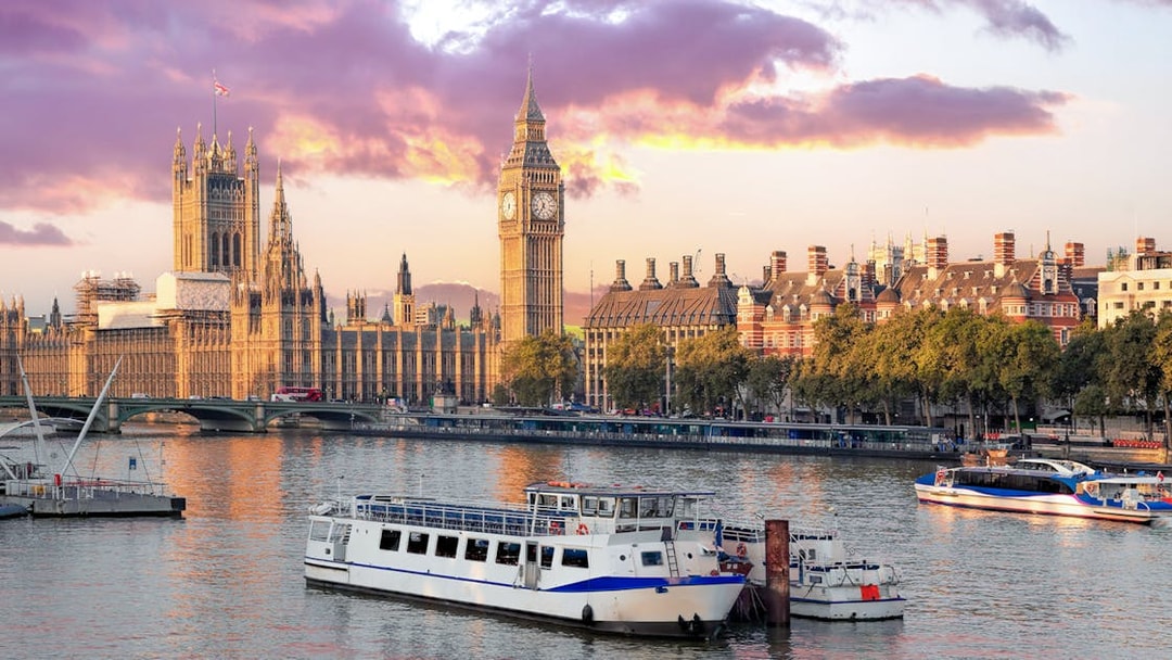 Cruise boat on Thames River with view of Big Ben and Houses of Parliament, London.