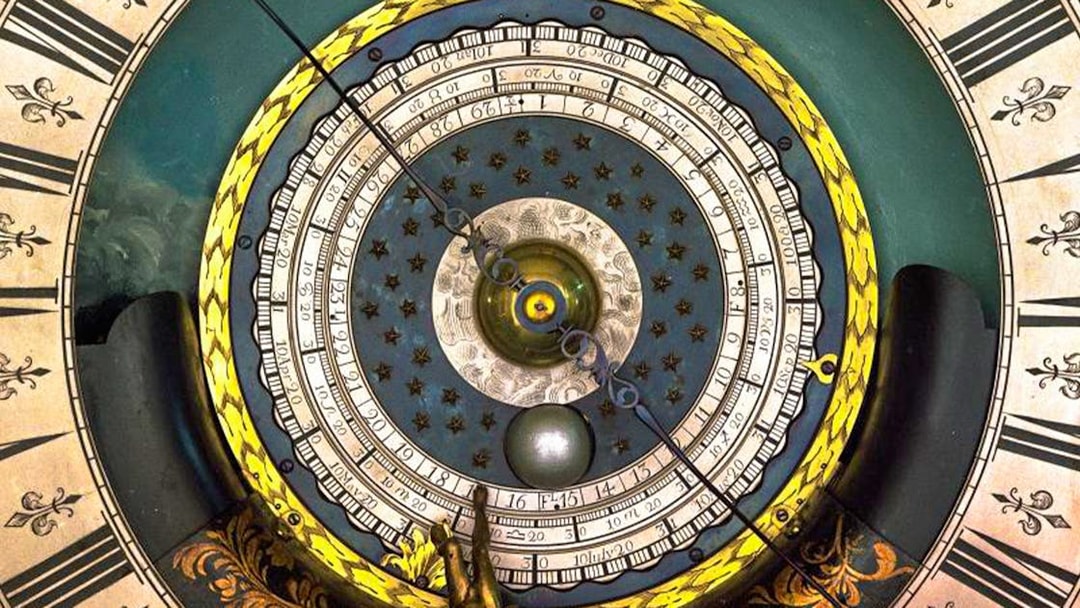 Astronomical clock face at Royal Observatory Greenwich, featuring intricate dials and celestial motifs.