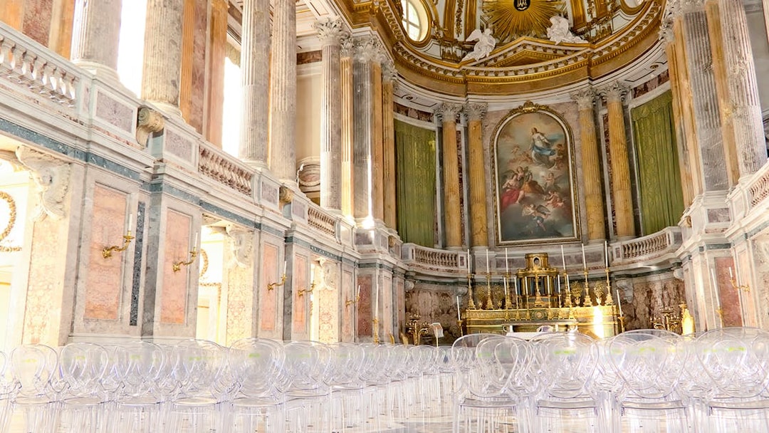 Royal Palace interior with ornate columns and grand altar, featuring clear seating for visitors.