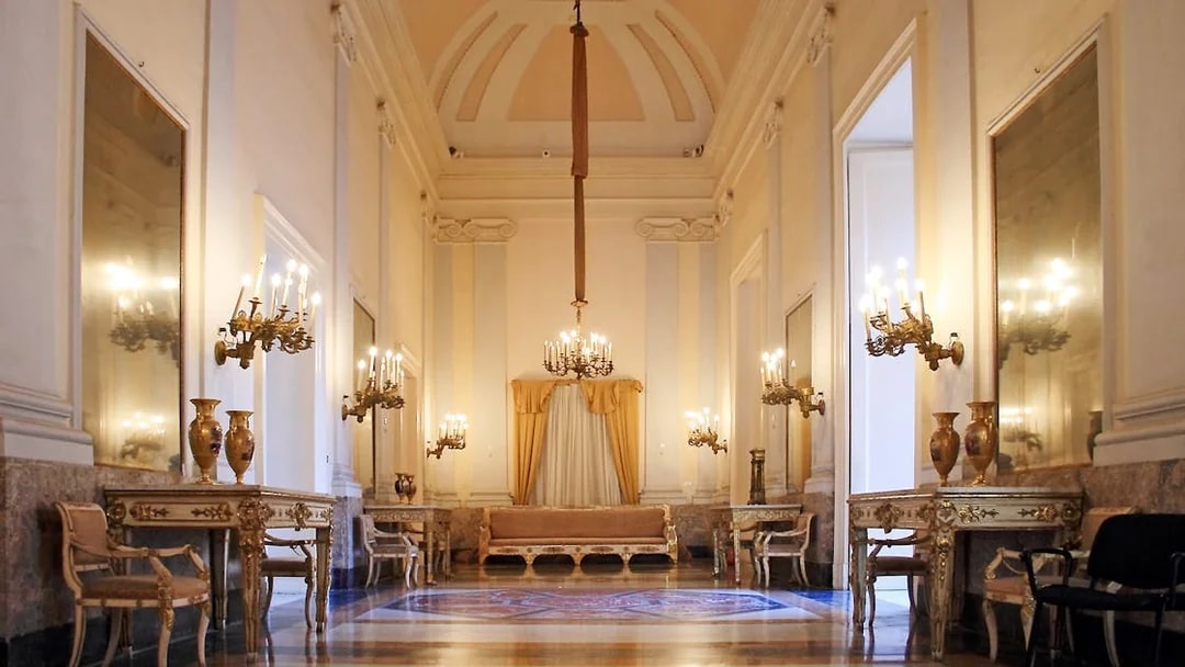 Royal Palace of Naples historic apartment with chandeliers and ornate furniture.