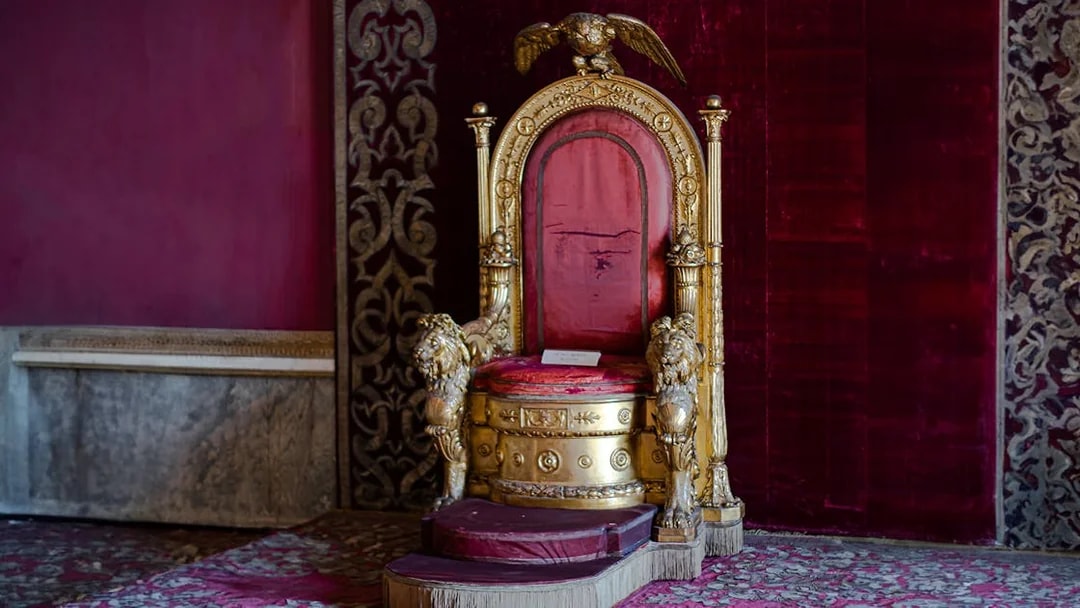 Throne in the Royal Palace of Naples with ornate gold and red design.