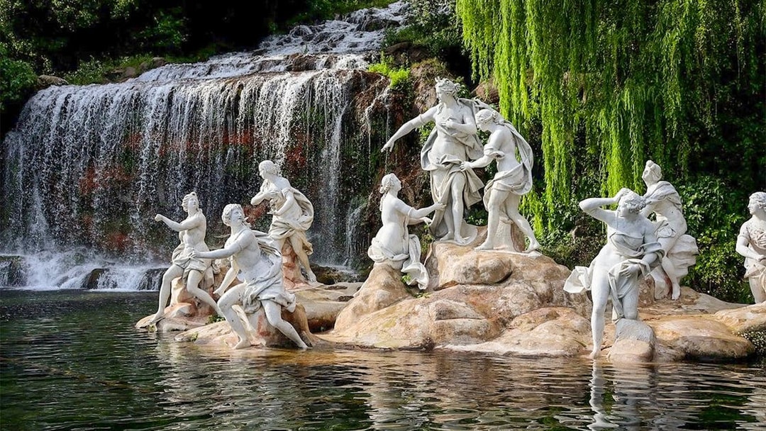 Statues near waterfall at Royal Palace of Caserta gardens.