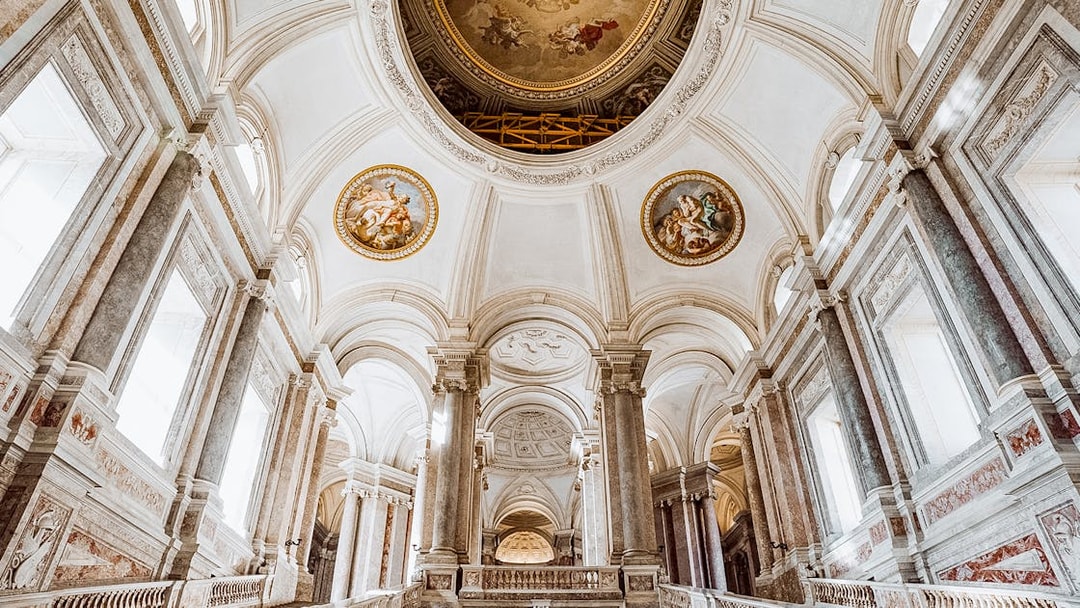 Royal Palace of Caserta vaulted ceiling with ornate frescoes and grand columns.