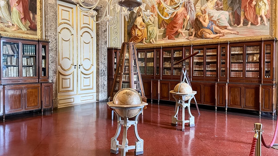 Royal Palace of Caserta library with globes and bookshelves.