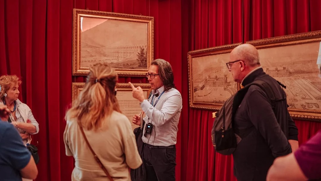 Guide explaining artwork to a small group at Royal Palace of Caserta tour.