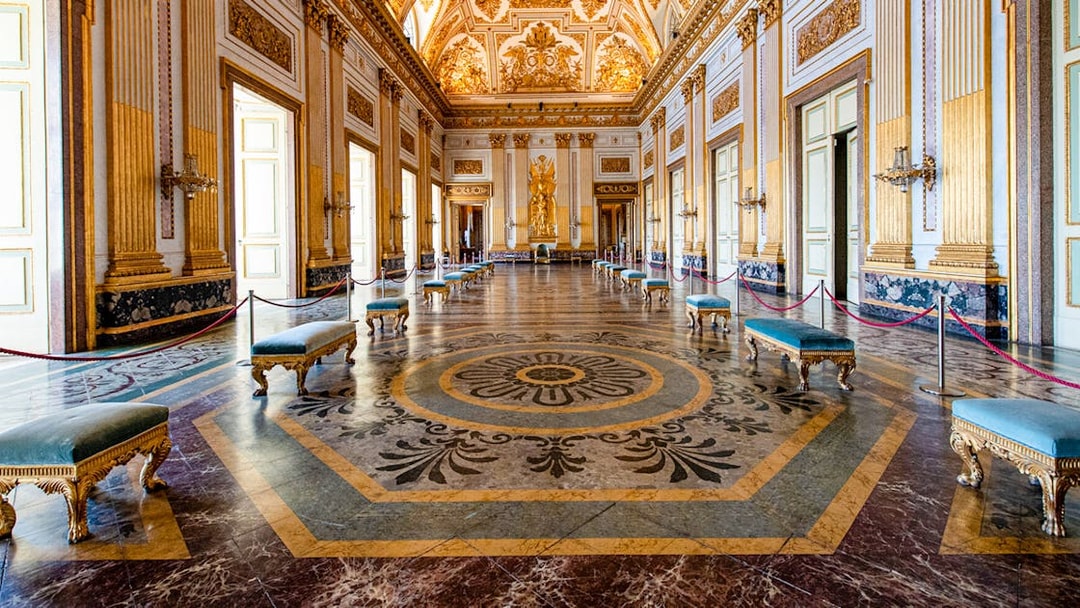 Royal Palace of Caserta interior with ornate ceiling and marble floor.
