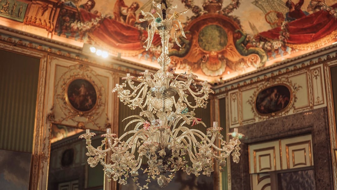 Elegant chandelier and ornate ceiling in the Royal Palace of Caserta.
