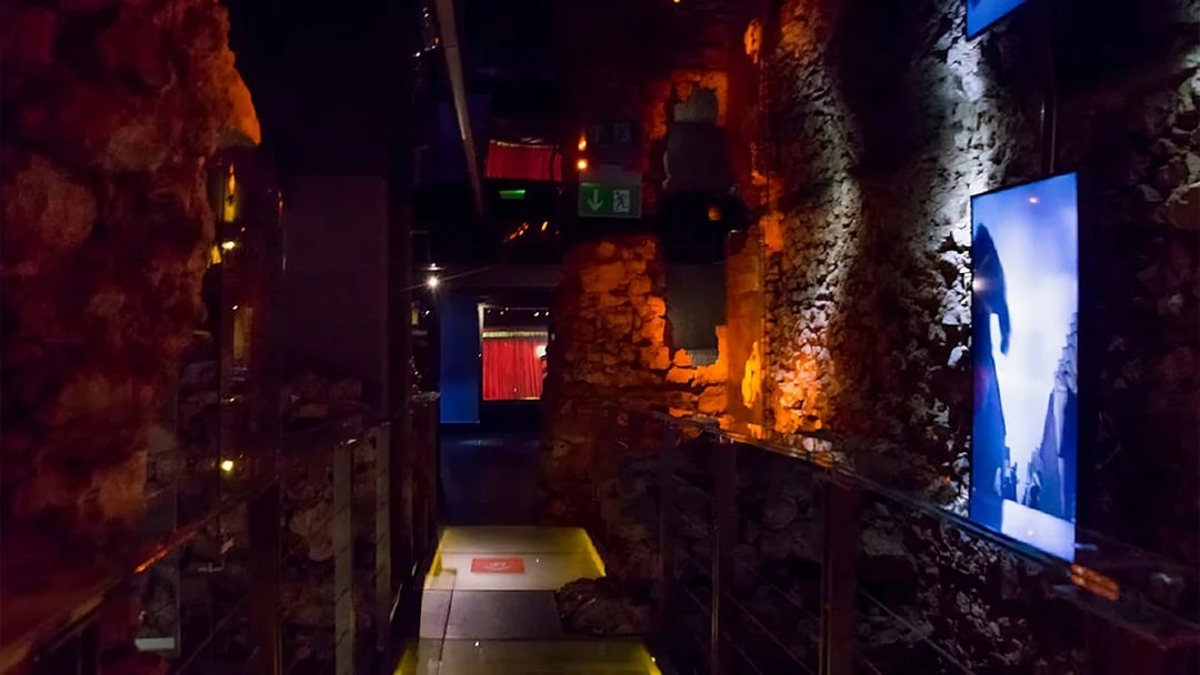 Rynek Underground Museum corridor with illuminated stone walls in Krakow.