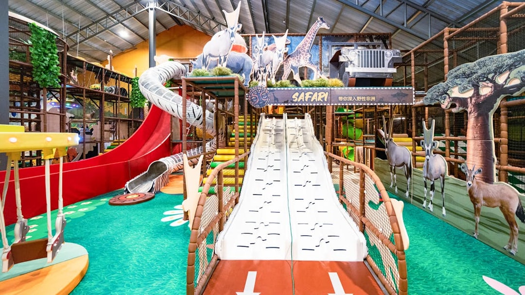 Indoor safari escape playland with slides, animal cutouts, and climbing structures.