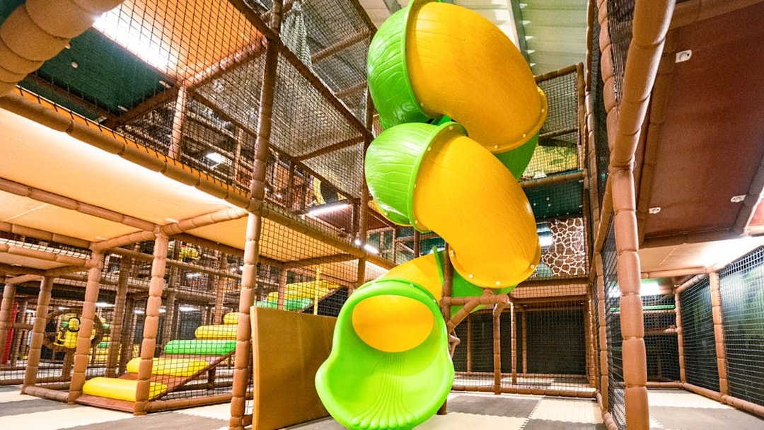 Indoor safari playland with spiral slide and climbing structures.