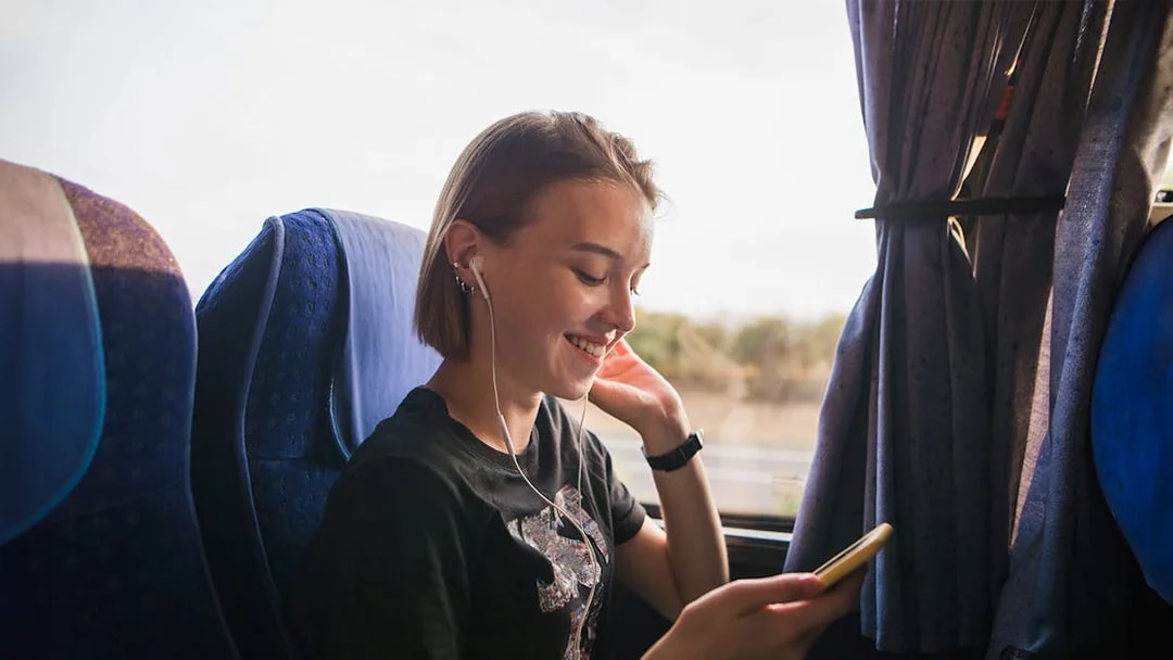 Person listening to music on a coach transfer.