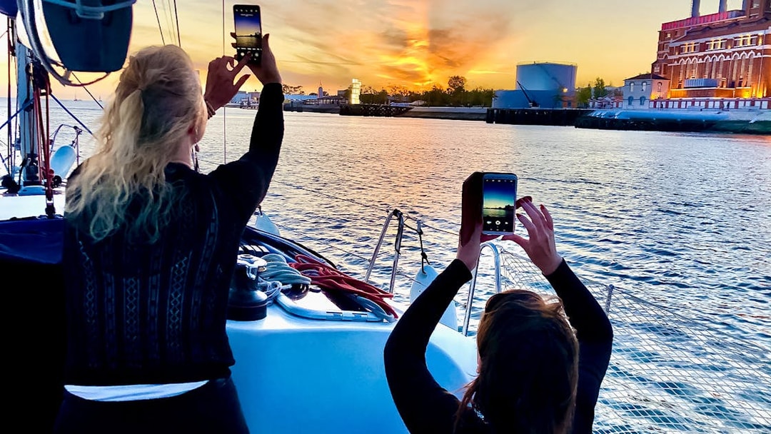 People photographing sunset on a Tagus River cruise in Lisbon.