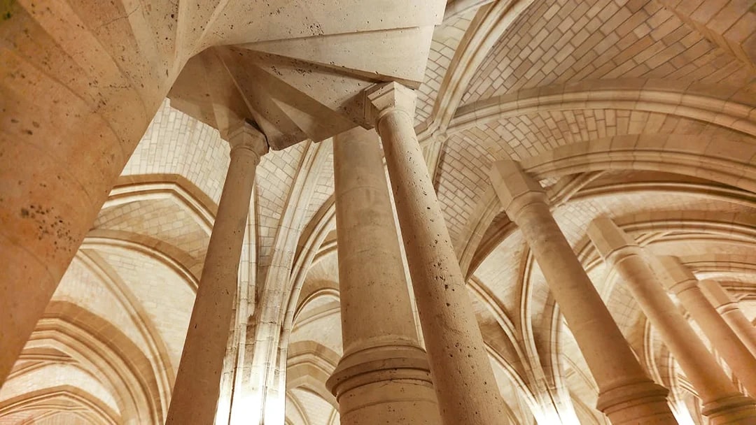 Sainte Chapelle stone columns and vaulted ceilings in Paris.