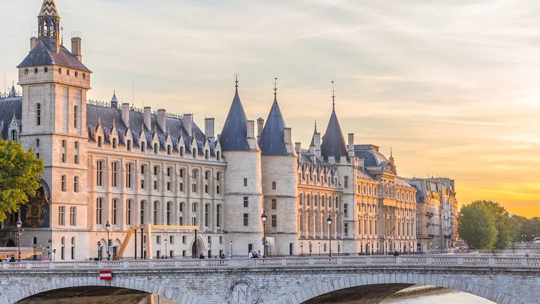 Conciergerie and Seine River at sunset in Paris.
