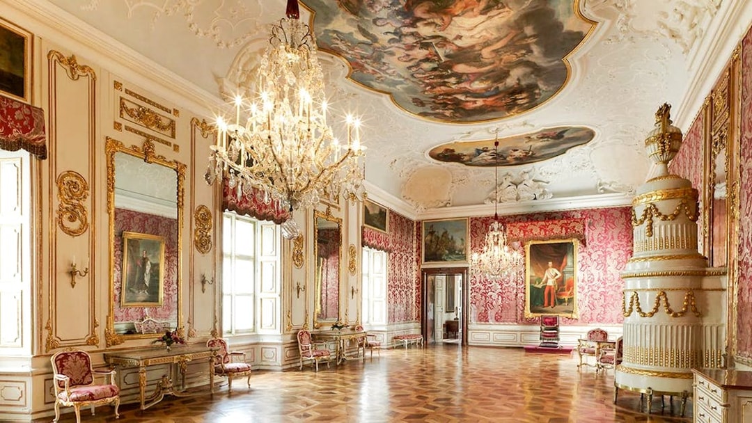Elegant room in Salzburg's Mirabell Palace with chandeliers and ornate decor.