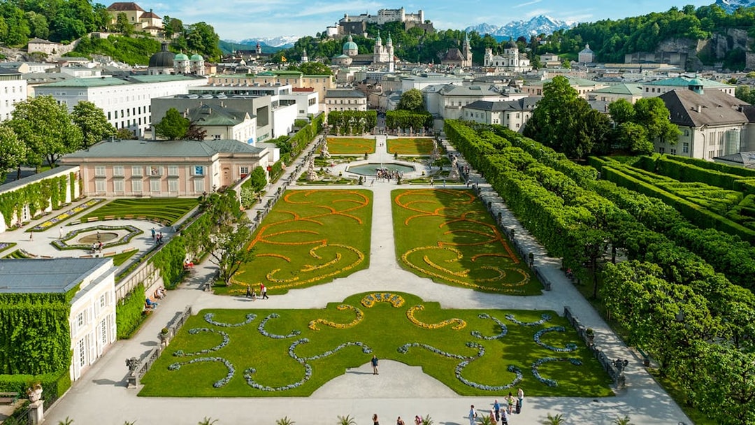 Mirabell Garden in Salzburg with geometric flower beds and view of Hohensalzburg Fortress.