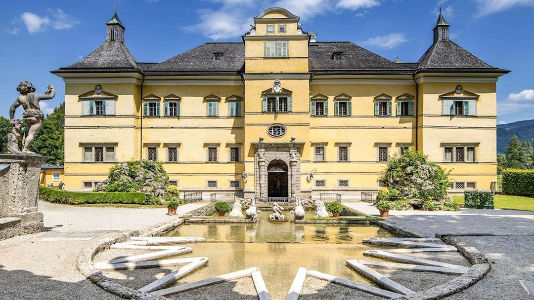 Hellbrunn Palace exterior with fountain and statues in Salzburg, Austria.