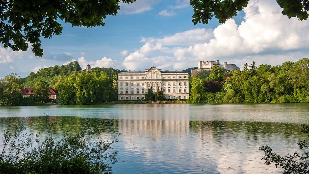 Schloss Leopoldskron by a lake with Hohensalzburg Fortress in Salzburg.