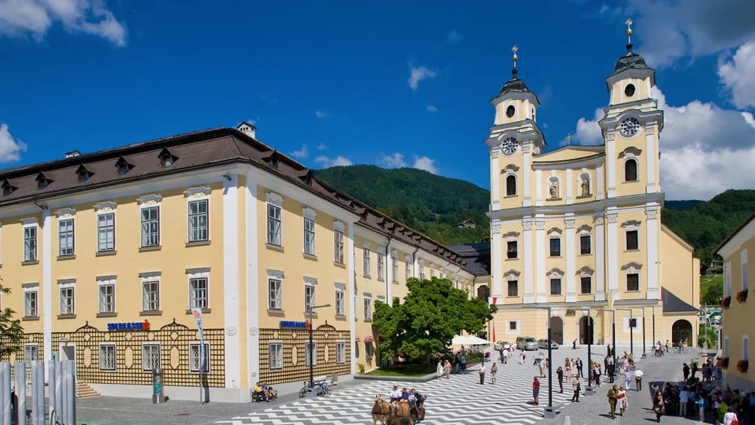 Salzburg's Mondsee Basilica with tourists in the square, part of the Sound of Music tour.