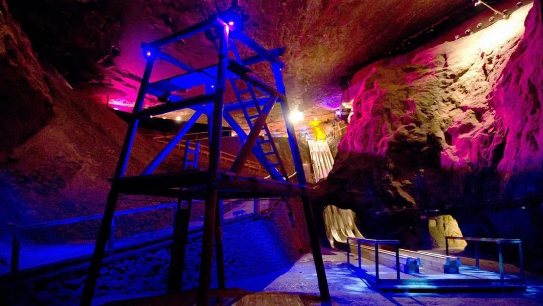 Salt mine interior with colorful lights and wooden slides, Salzburg tour.