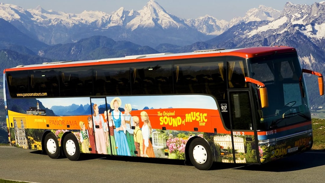 Tour bus for Salzburg Sound of Music and Salt Mines against Alps backdrop.