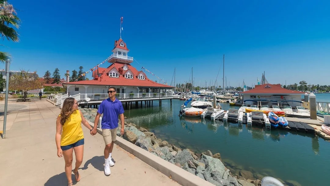 Couple walking near marina and historic building on Old Town Trolley Tour.