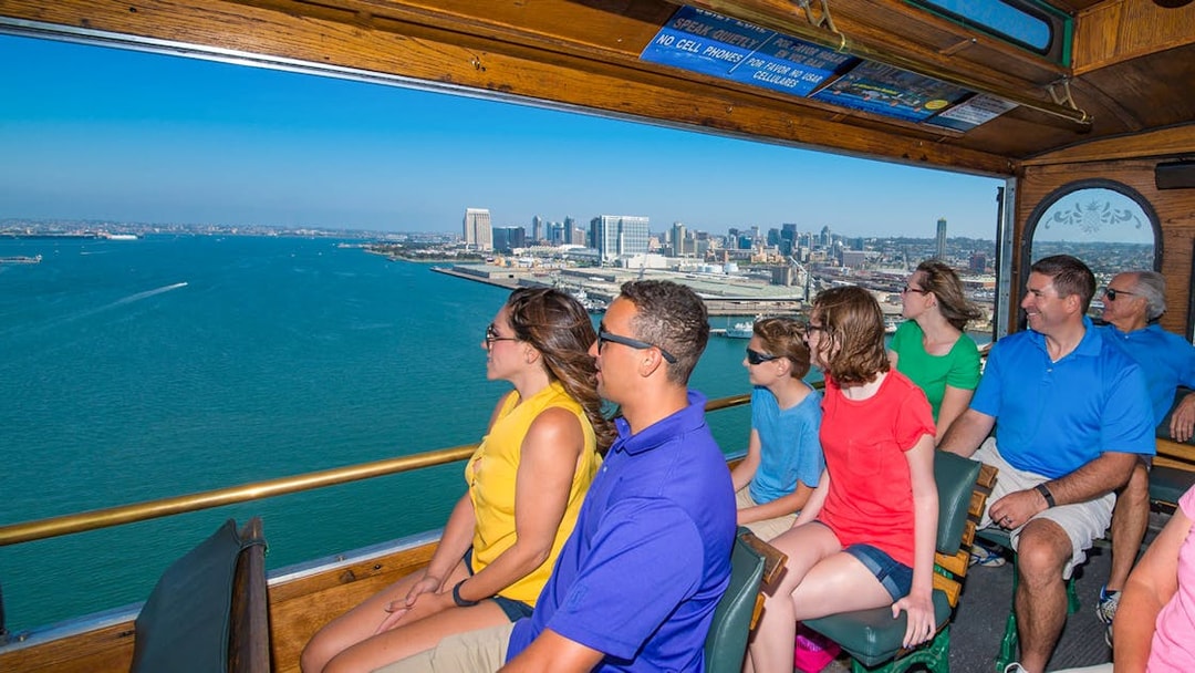Tourists enjoying a scenic view of the San Diego skyline from an Old Town trolley.