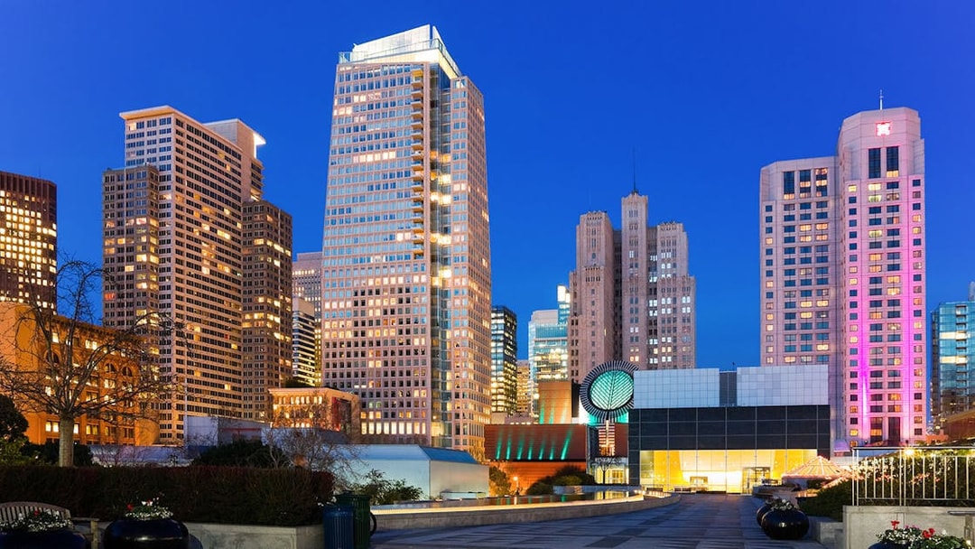 San Francisco Museum of Modern Art with city skyline at dusk.