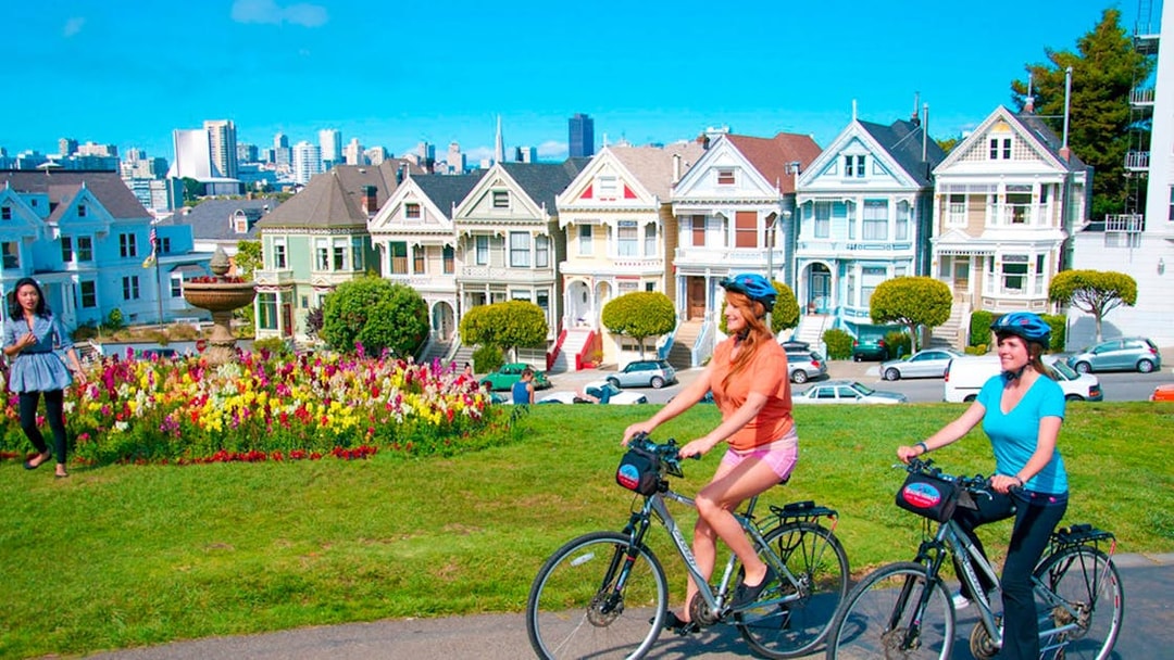 Cyclists ride past the Painted Ladies in San Francisco.