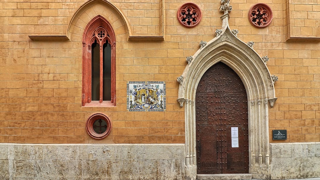 San Nicolas Church ornate wooden door with Gothic arch in Valencia, Spain.
