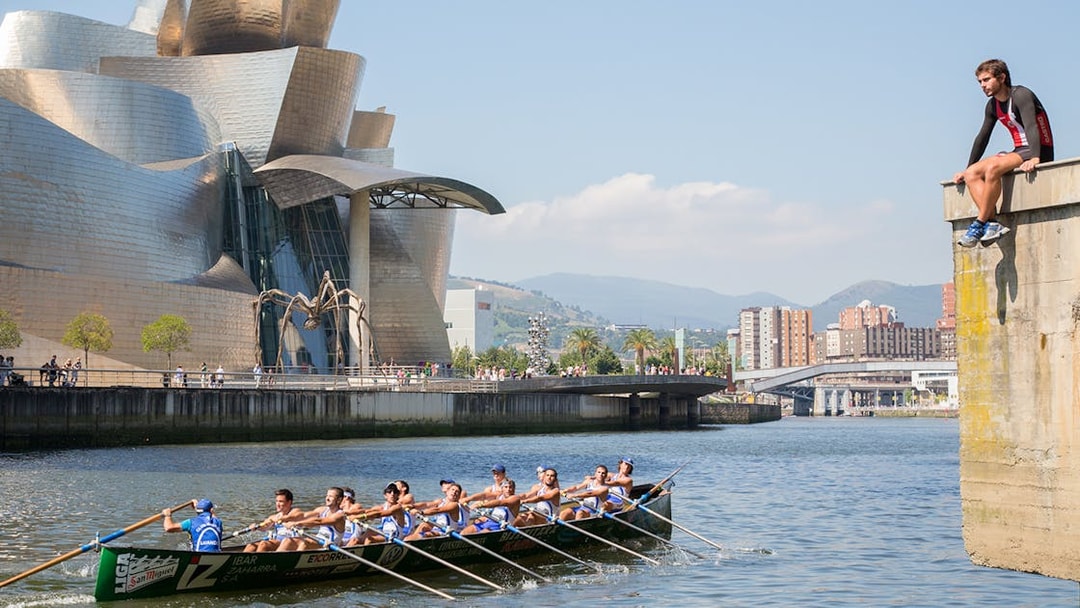 Rowers on the river near Guggenheim Museum Bilbao during Gaztelugatxe tour from San Sebastian.