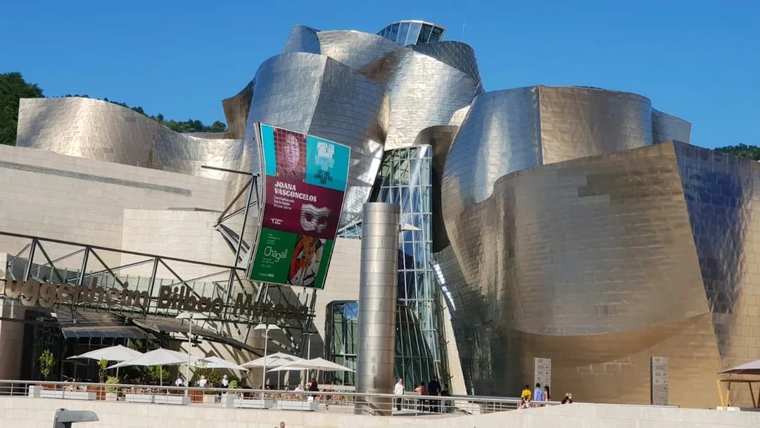 Guggenheim Museum Bilbao exterior with visitors, part of San Sebastian tour.