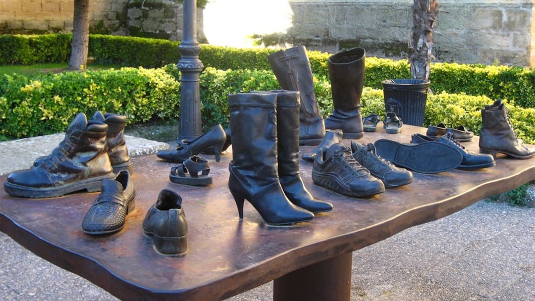 Sculpture of shoes on a table in a garden at a Rioja winery during a guided tour from San Sebastian.
