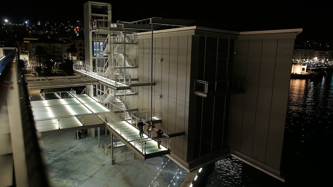 Centro Botín in Santander at night with illuminated walkways and water reflections.