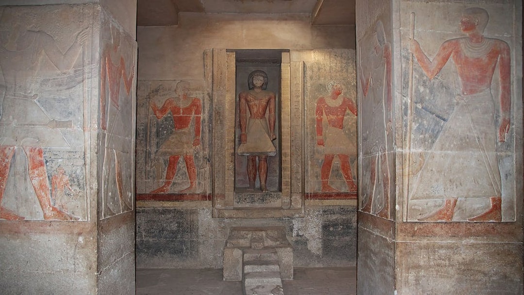 Ancient Egyptian frescoes and statue in Saqqara necropolis, Egypt.