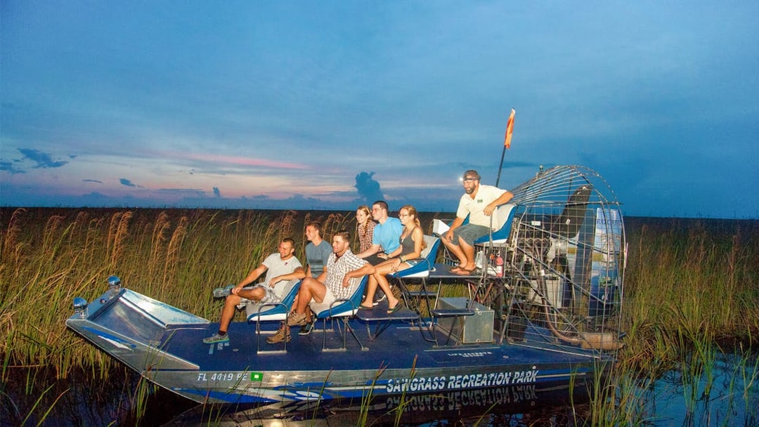 Group on an airboat during a night tour in the Everglades, surrounded by marshland.