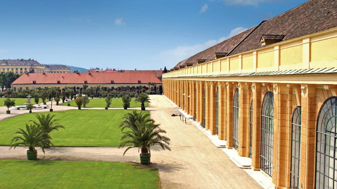 Schönbrunn Palace exterior with gardens and palm trees, Vienna, Austria.