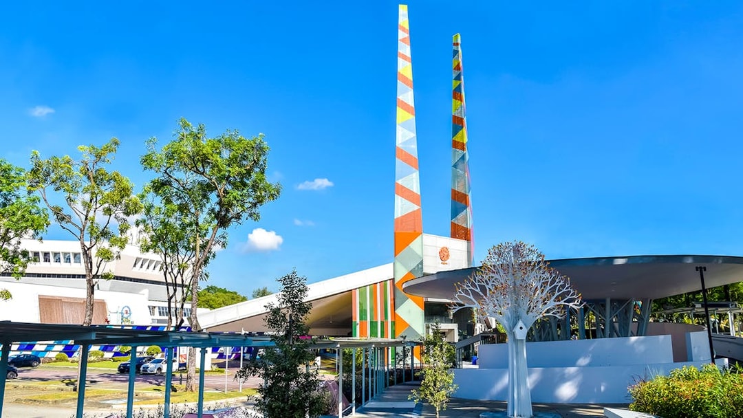Visitors at Science Centre Singapore with colorful towers and modern architecture.