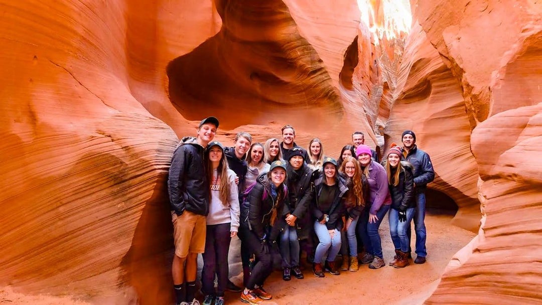 Group of tourists exploring Secret Antelope Canyon's sandstone formations.
