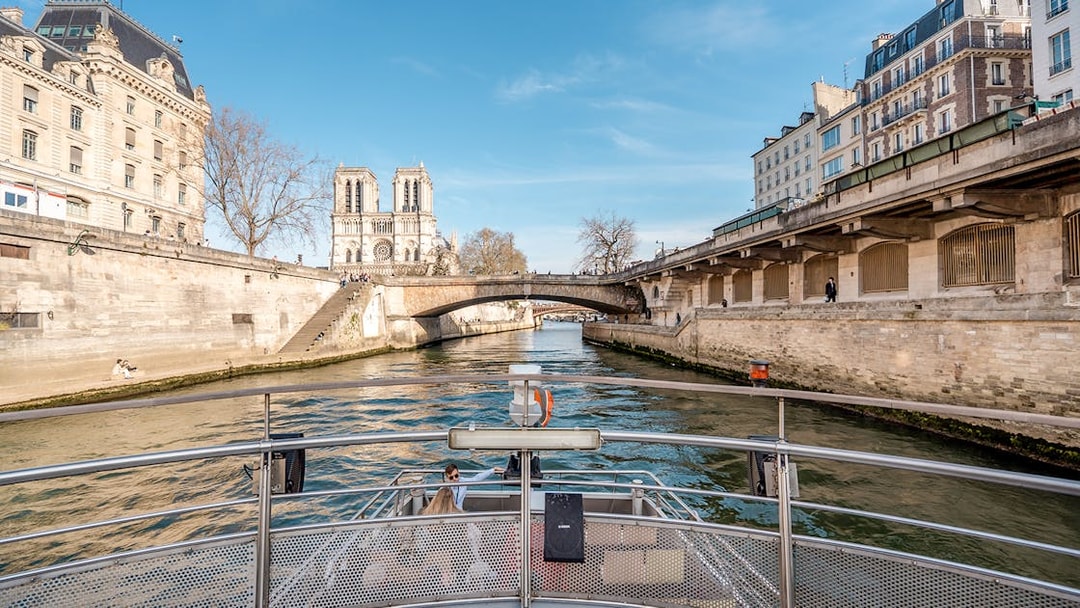 Seine River cruise view with Notre-Dame Cathedral and Parisian architecture.