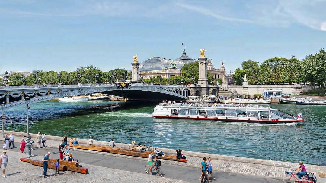 Seine River cruise boat passing under Pont Alexandre III in Paris.