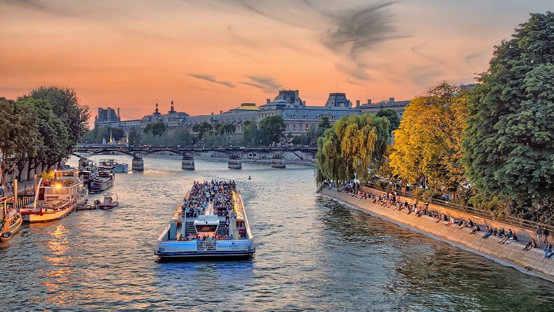 Seine River cruise boat with passengers enjoying a morning view in Paris.