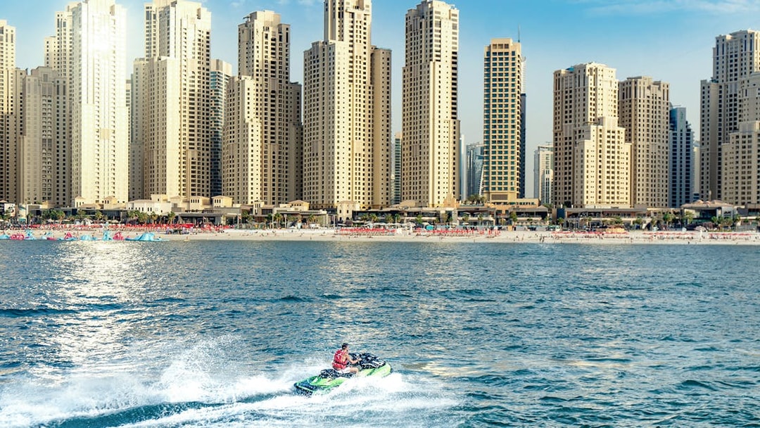 Jet ski rider on Dubai waters with city skyline in the background.