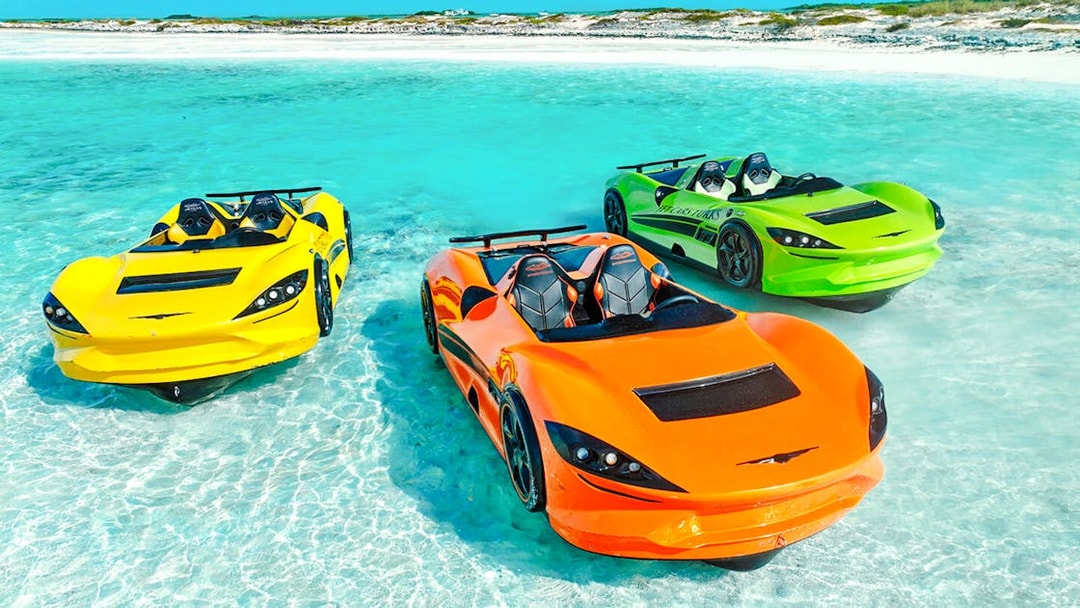 Three colorful Jet cars floating on clear water at Dubai shore.
