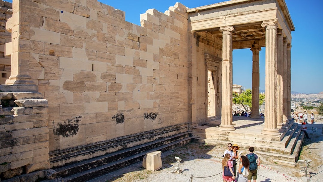 Visitors exploring the Erechtheion temple on the Acropolis in Athens, Greece.