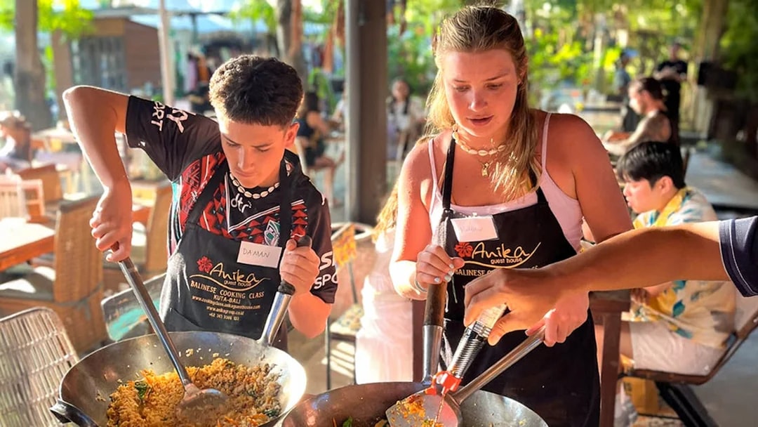 Participants cooking at Nia Balinese Cooking Class in Kuta, Bali.