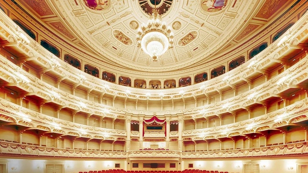 Semperoper Dresden auditorium with ornate ceiling and red seating.