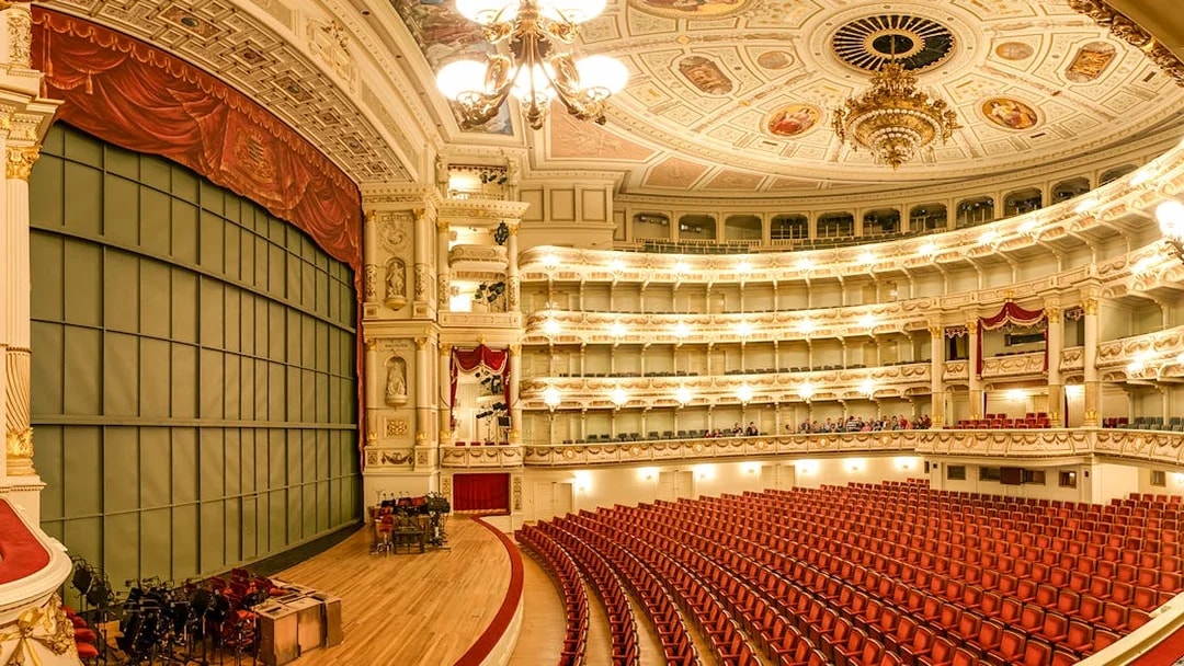 Semperoper Dresden auditorium with ornate ceiling and red seating.