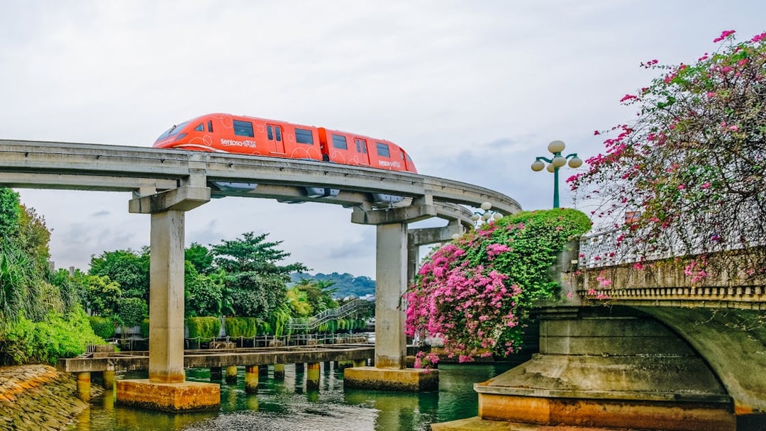 Monorail traveling over a bridge on Sentosa Island, Singapore, surrounded by lush greenery.